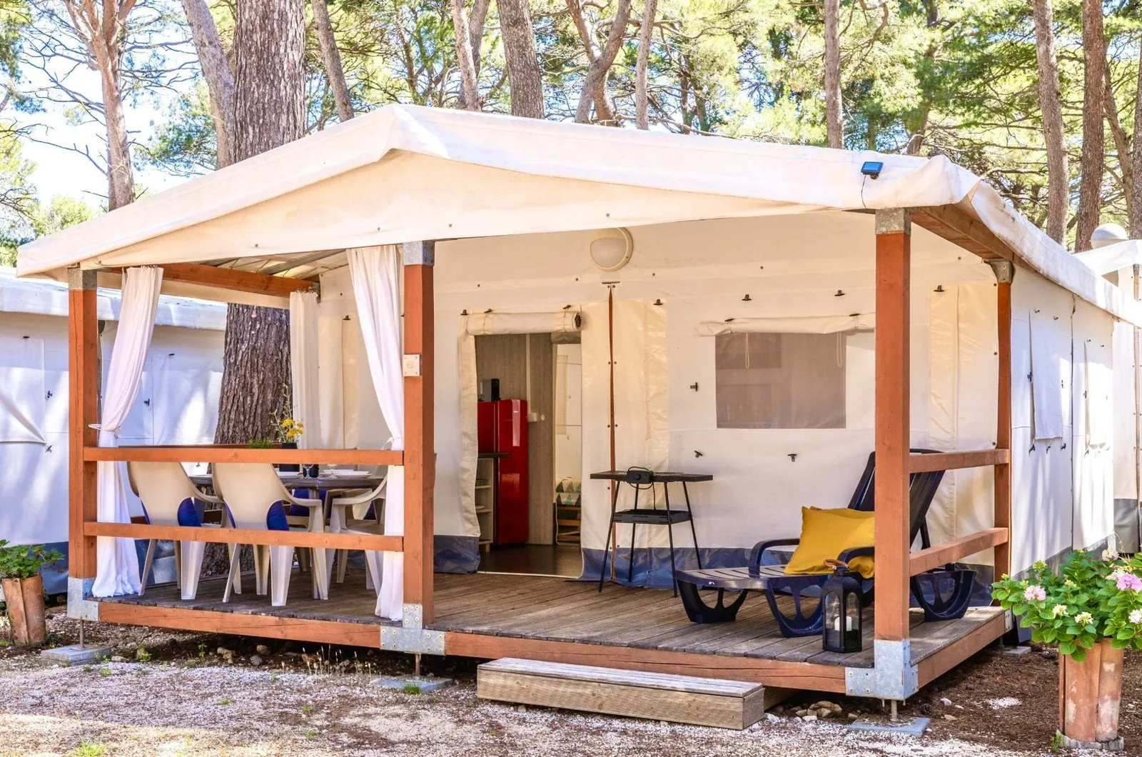 Glamping PLUS safari tent with a covered wooden terrace among pine trees at Camp Čikat