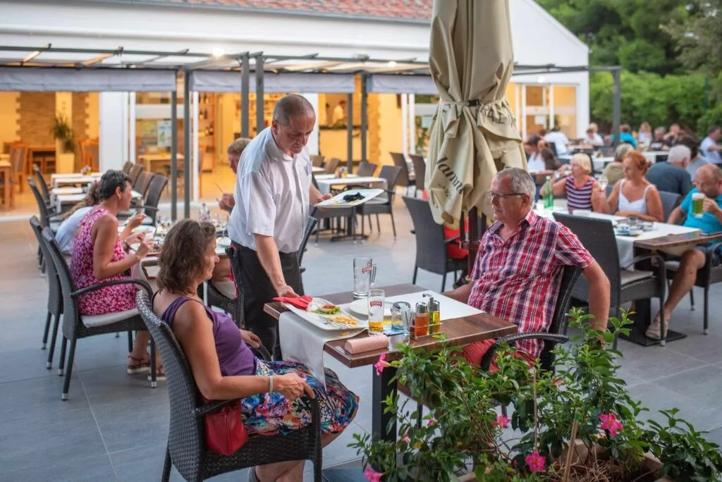 Guests dining on an outdoor restaurant terrace at Camp Adriatic near Primošten